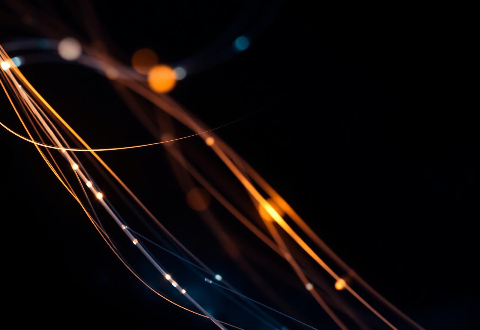 Warm fiber-optic strands crossing a dark field, representing connected technology systems